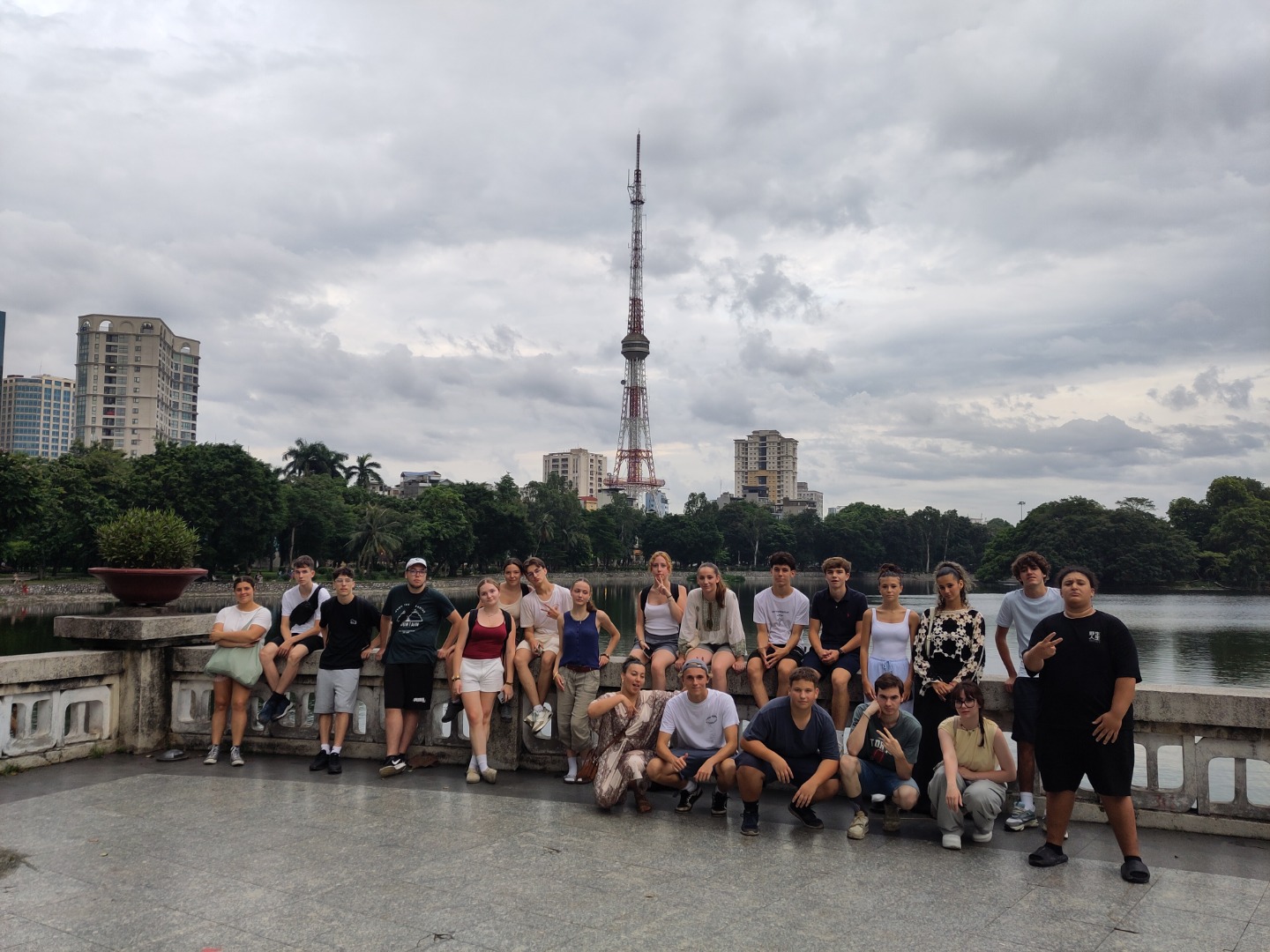 Groupe d’adolescents CEI posant devant le lac et la tour de télévision de Hanoï