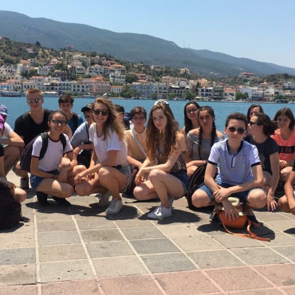 Des adolescents prennent une photo devant la mer pendant leur colonie de vacances en Grèce.