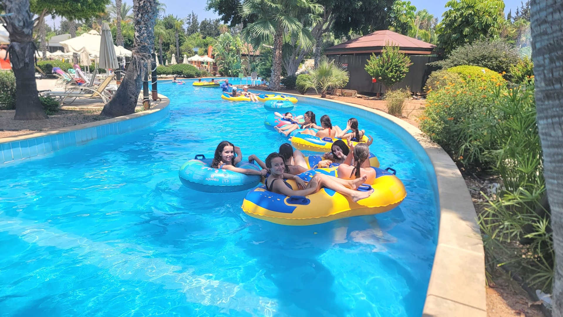 Groupe d’adolescents en bouées gonflables dans une rivière lente d’un parc aquatique à Chypre.
