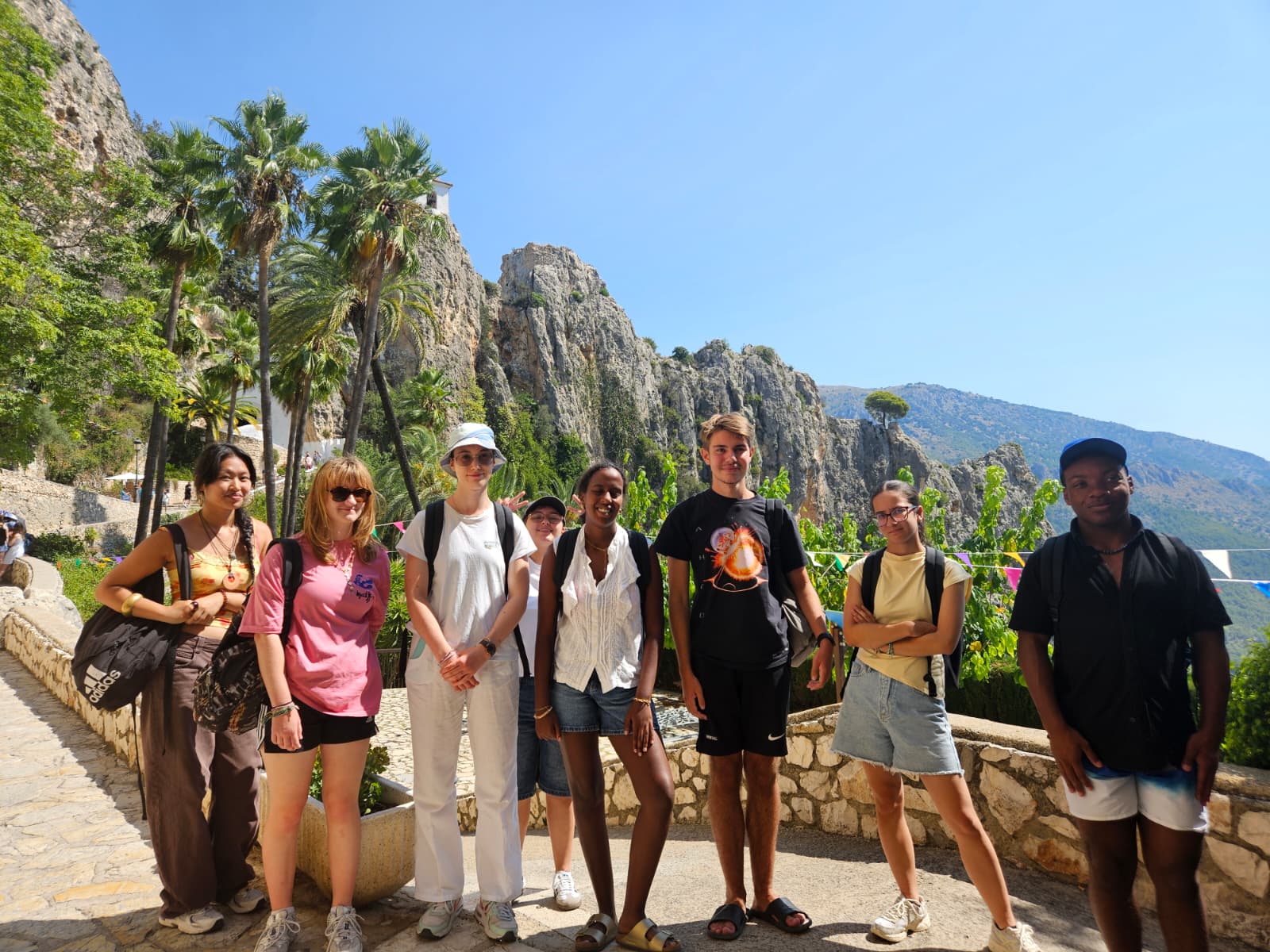 Groupe d’adolescents souriants en excursion, entourés de montagnes et de palmiers lors d’un séjour linguistique à Alicante.