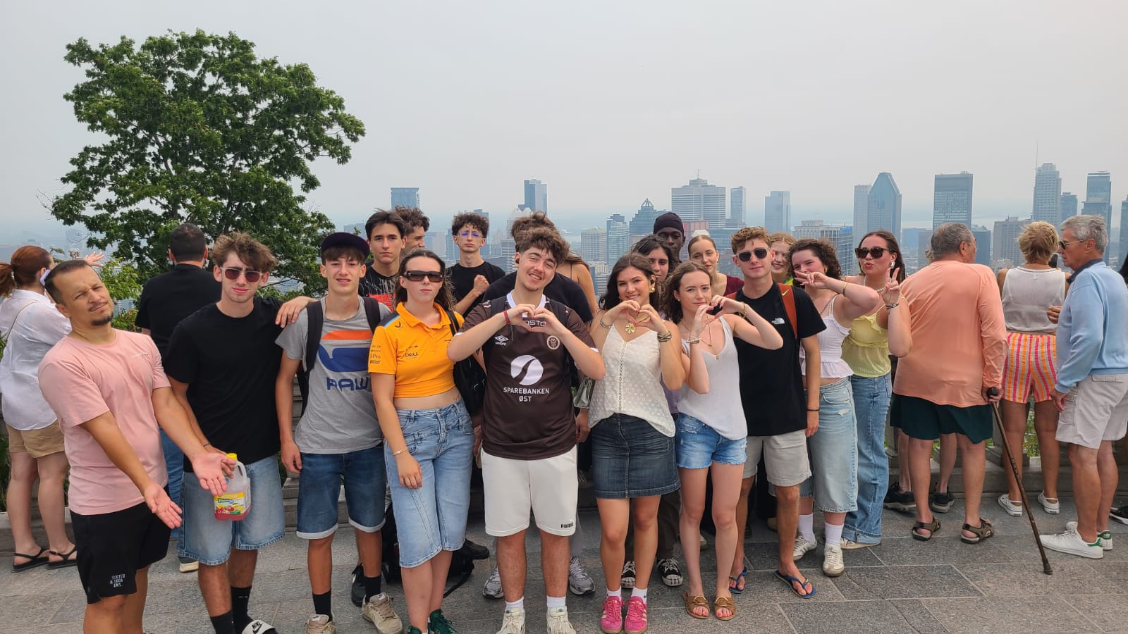 Groupe CEI de jeunes en colonie de vacances posant avec vue sur Montréal depuis le Mont Royal.