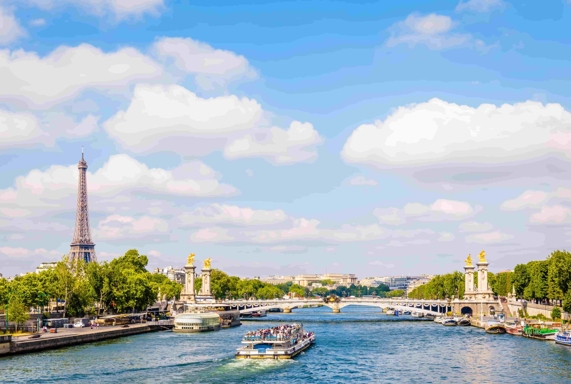 Participants of the Cooking Tour in Paris enjoying a cruise on the Seine with views of the Eiffel Tower and Pont Alexandre III.