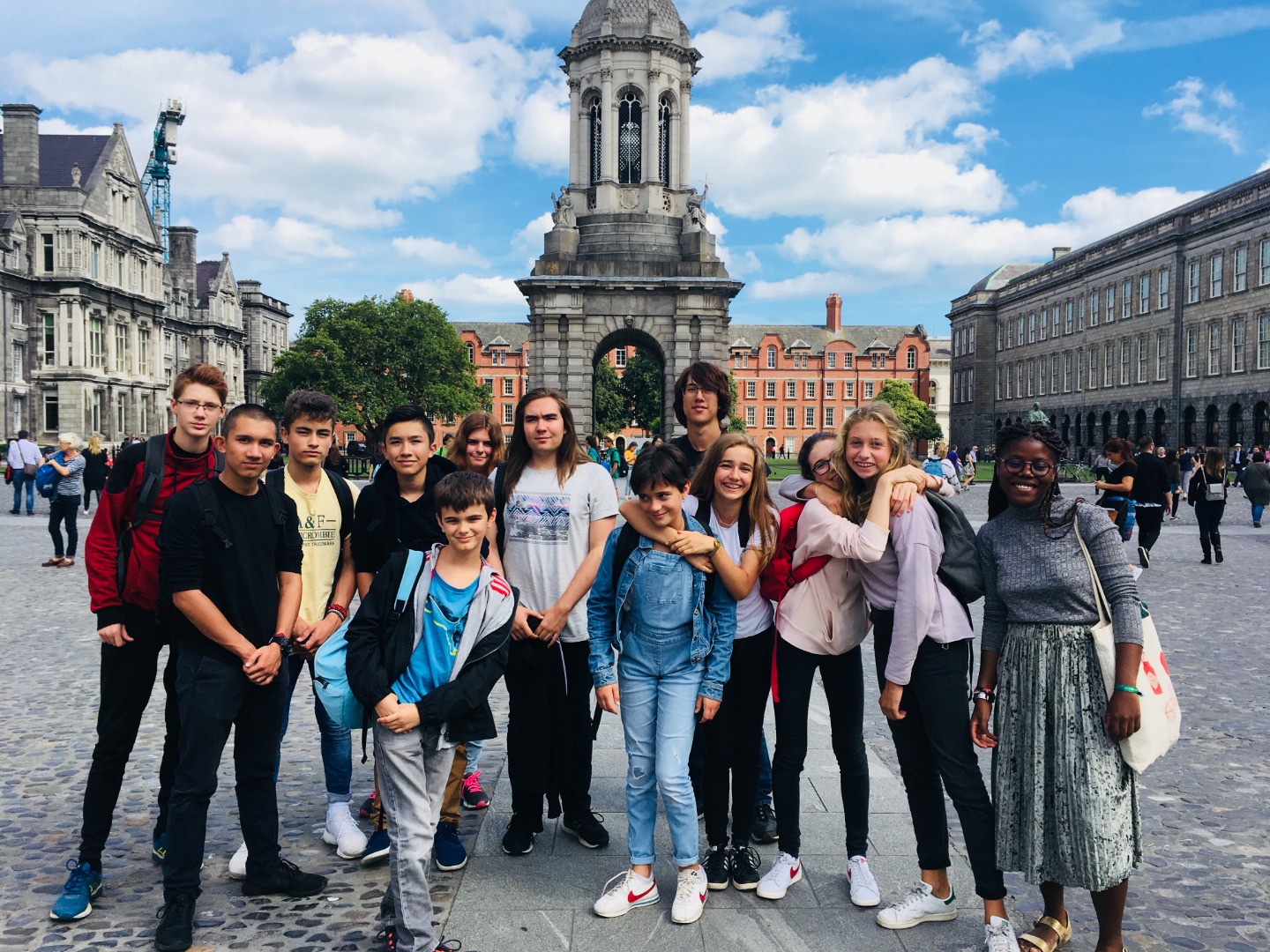 Groupe d’adolescents en séjour linguistique à Dublin posant devant le bâtiment historique de Trinity College.