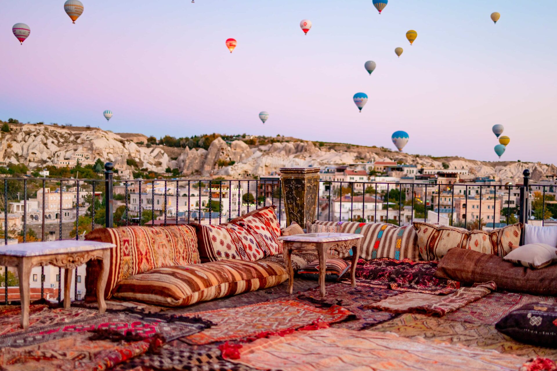 Un rooftop typique de Cappadoce offrant une vue imprenable sur les montgolfières au lever du soleil – un moment inoubliable pendant la colonie de vacances.
