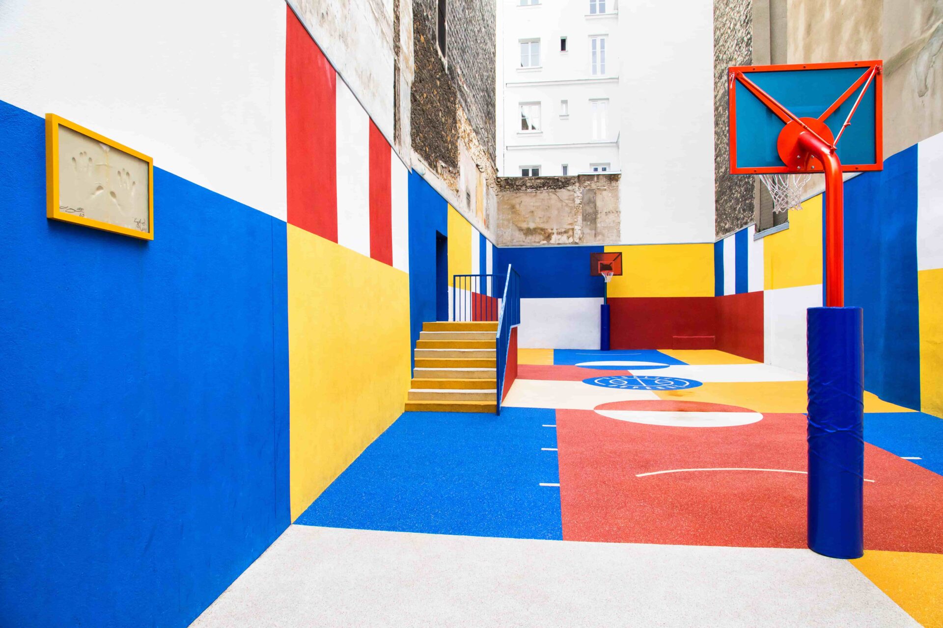 Colorful Duperré basketball court in Paris with modern urban design and red, blue, yellow paint.