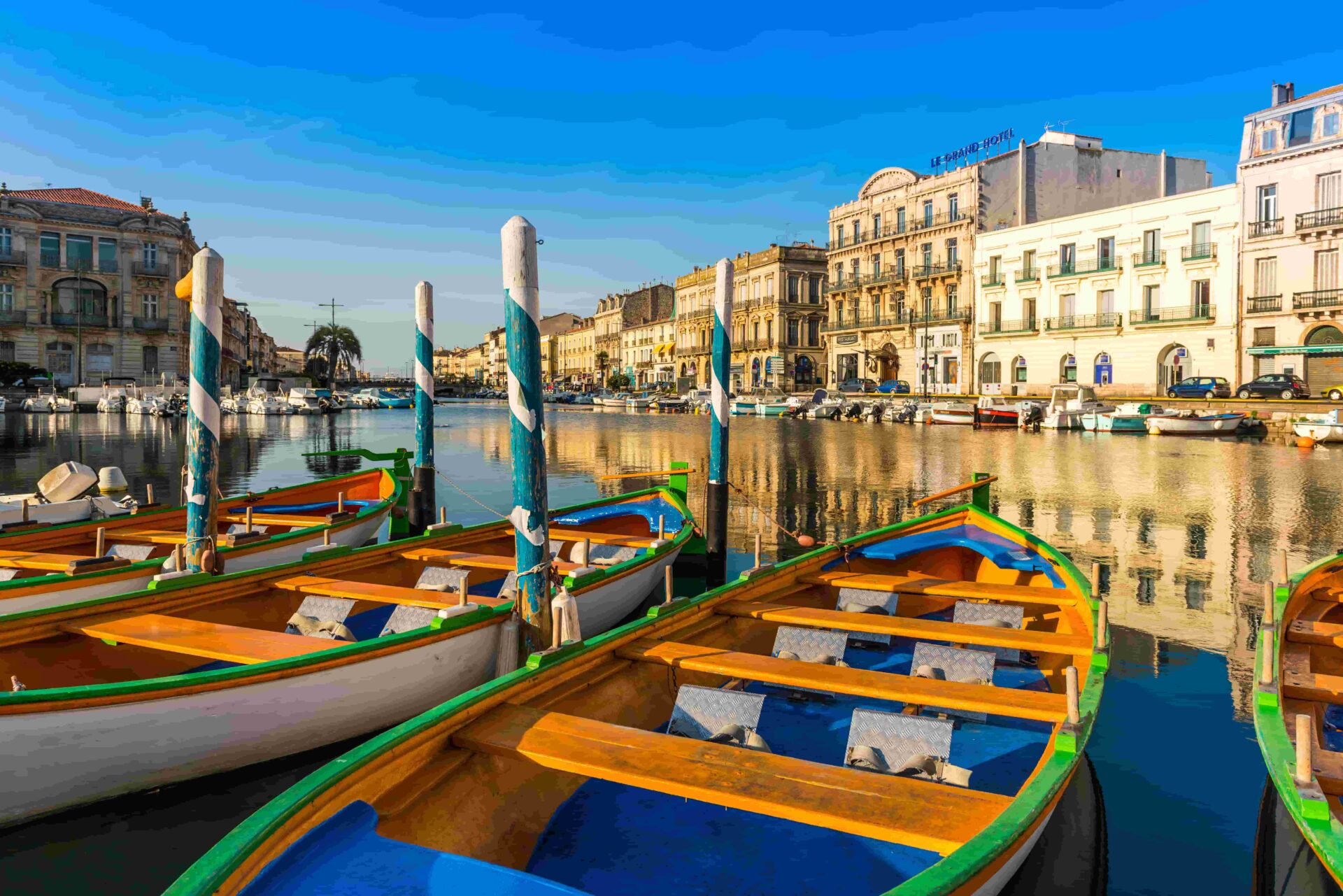 View of colorful wooden boats docked along the canal in Sète, France, reflecting the charm and tradition of this seaside town during a CEI camp tour.