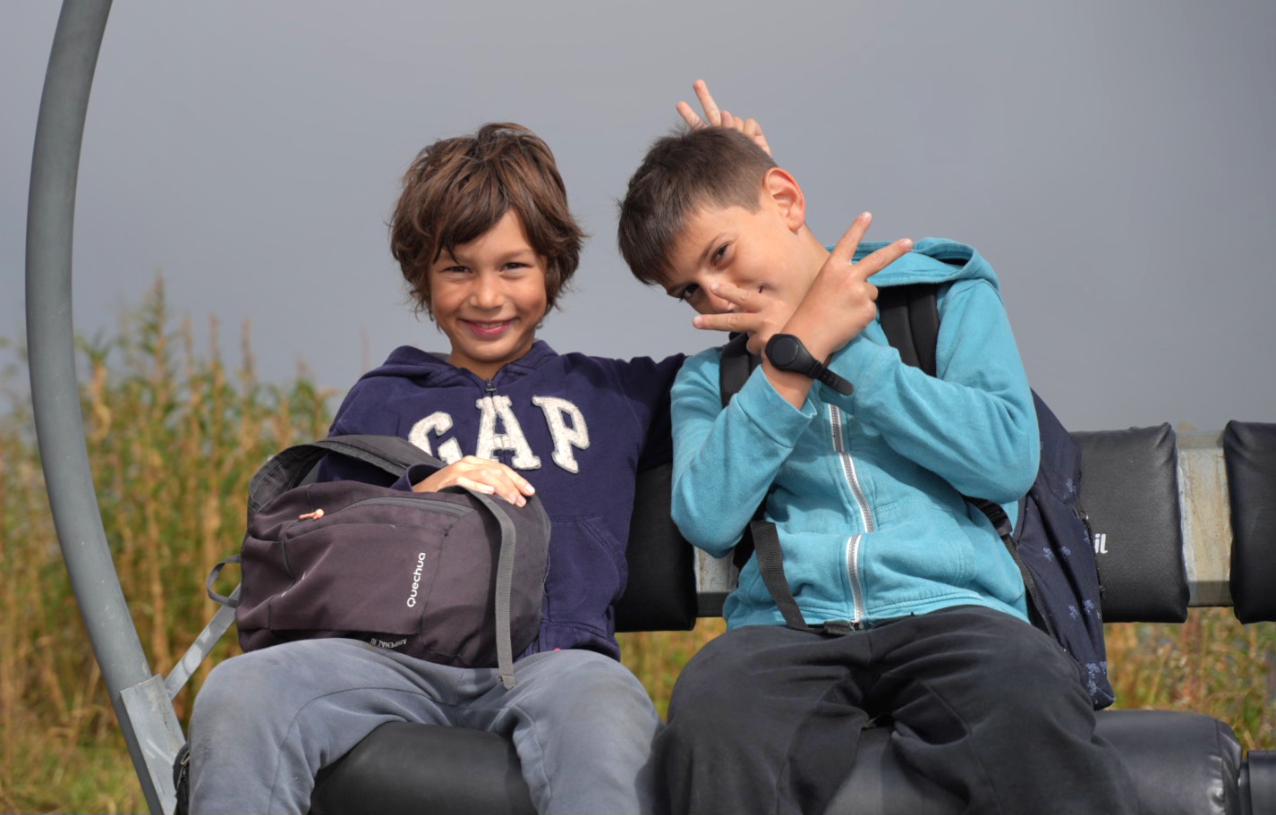 Deux enfants souriants assis ensemble pendant une activité de la colonie de vacances été.