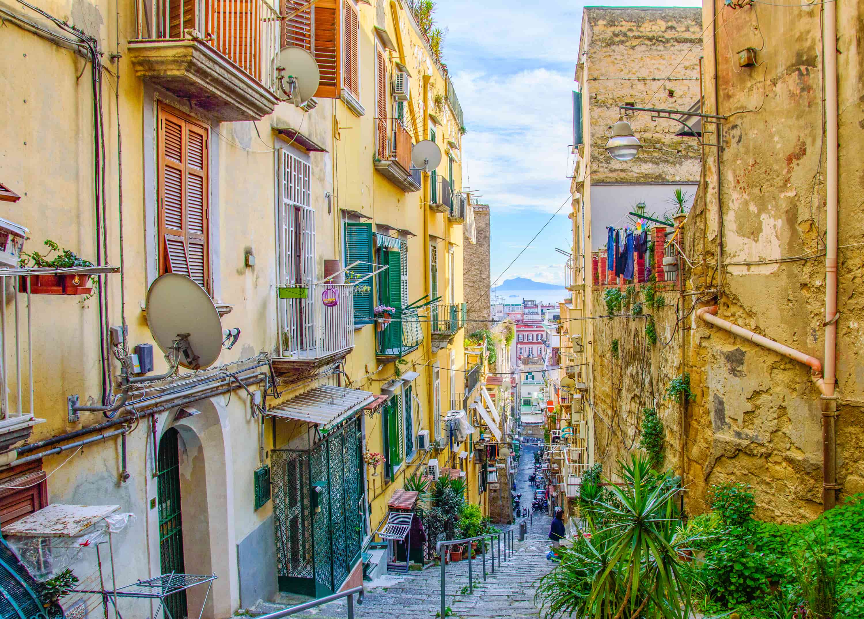 Ruelle colorée de Naples avec vue sur la mer, découverte pendant une colonie de vacances à Naples.